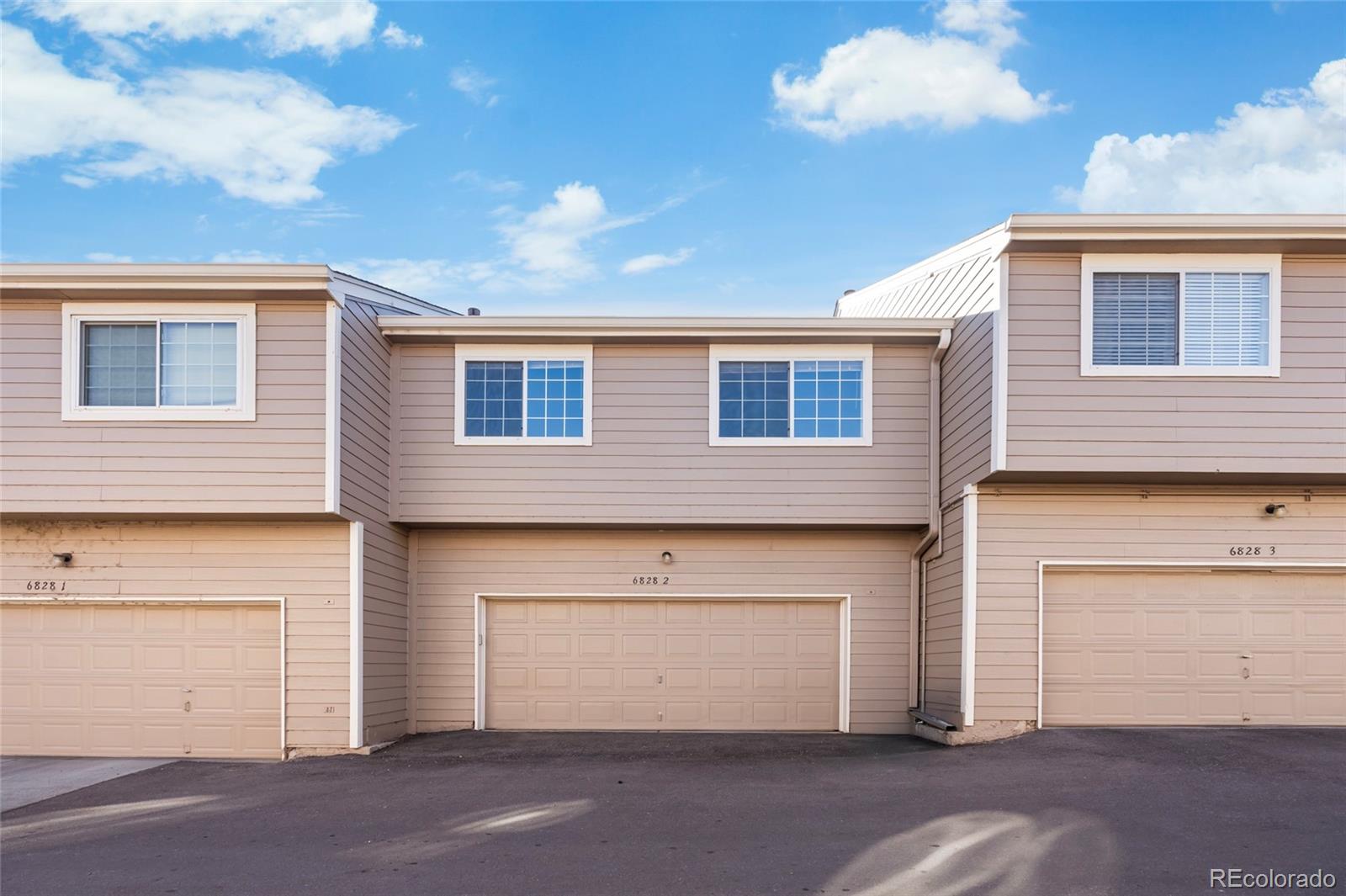 6828 Zenobia Street, Unit 2 Westminster, CO 80030 - Photo 4 of 24 a front view of a house with a garage