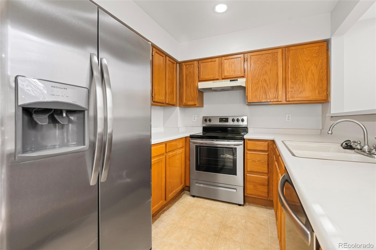 6828 Zenobia Street, Unit 2 Westminster, CO 80030 - Photo 5 of 24 a kitchen with stainless steel appliances granite countertop a sink and a refrigerator