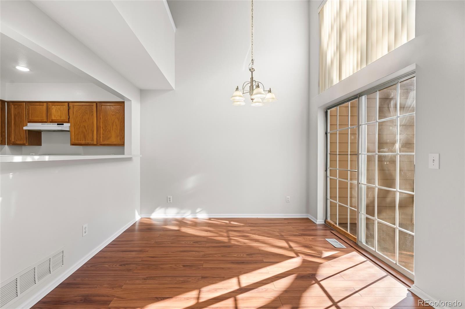 6828 Zenobia Street, Unit 2 Westminster, CO 80030 - Photo 8 of 24 a view of an empty room with wooden floor and a window