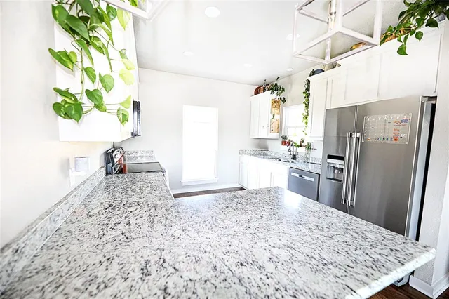 a bedroom with a bed and a flat tv screen on dresser