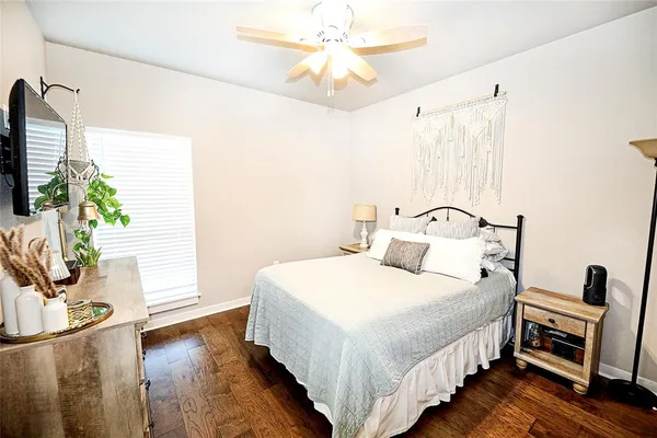 a bedroom with a bed and a flat tv screen on dresser