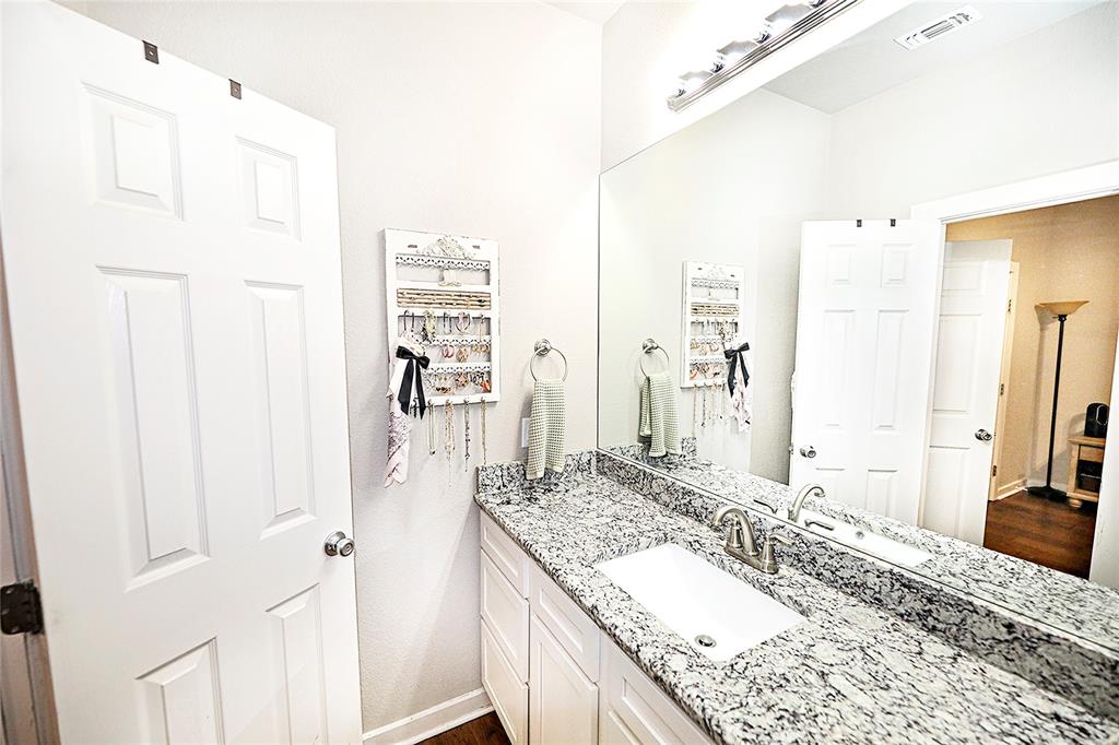 305 Main Street Nocona, TX 76255 - Photo 15 of 36 a bathroom with a granite countertop sink and a mirror