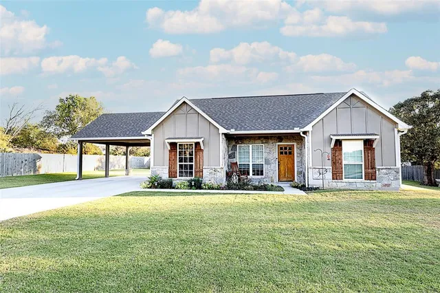 a front view of a house with a yard and trees