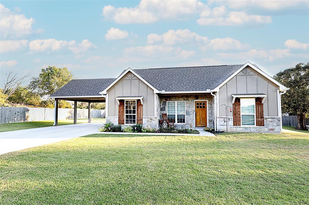 305 Main Street Nocona, TX 76255 - Photo 2 of 36 a front view of a house with a yard and trees