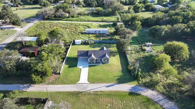 an aerial view of a house with a yard and lake view