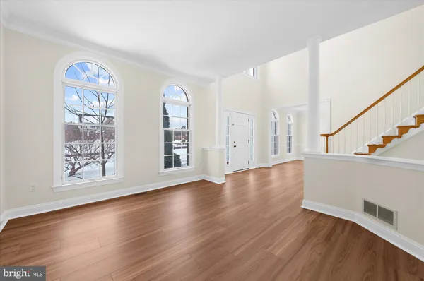 a view of a room with wooden floor and chandelier