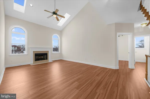 wooden floor fireplace and windows in an empty room