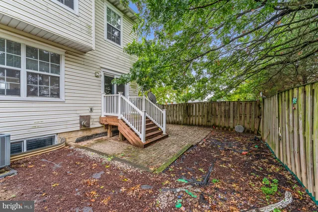 a view of a small house with wooden fence