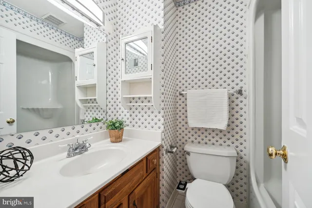 a bathroom with a sink a toilet and shower curtain