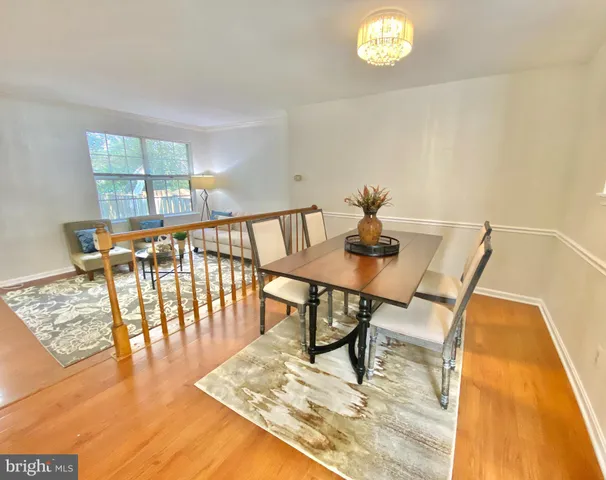 a view of a dining room with furniture a rug and wooden floor