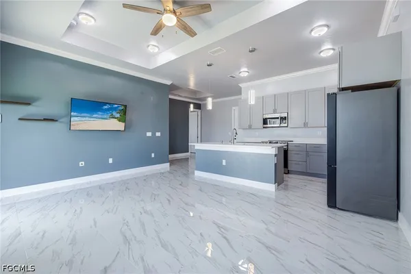 a large white kitchen with a large window stainless steel appliances and cabinets