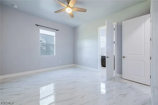 a view of an empty room with a chandelier fan