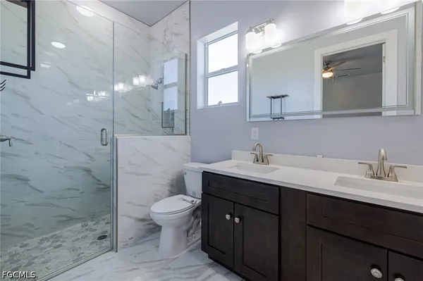 a bathroom with a double vanity sink toilet and shower