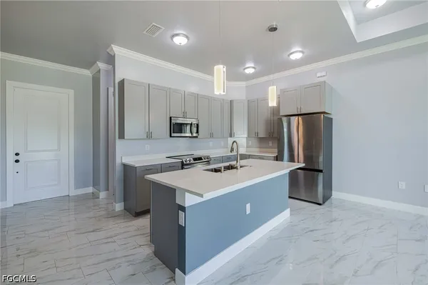 a kitchen with a sink a refrigerator and some cabinets