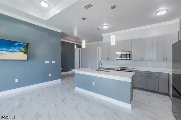a large kitchen with kitchen island a sink stainless steel appliances and cabinets