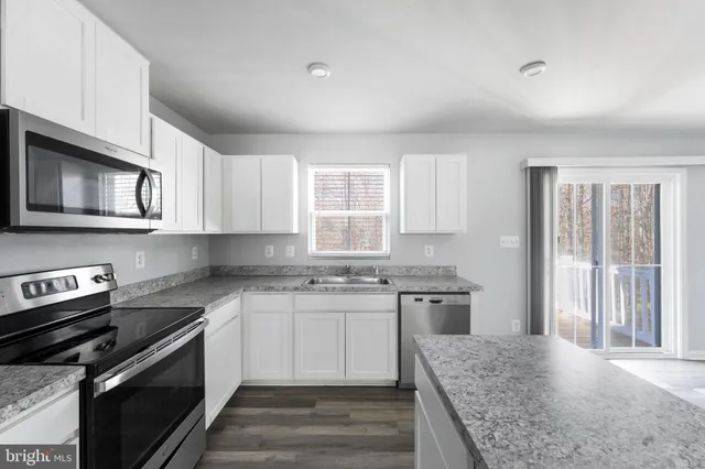 a kitchen with stainless steel appliances granite countertop a stove and a sink