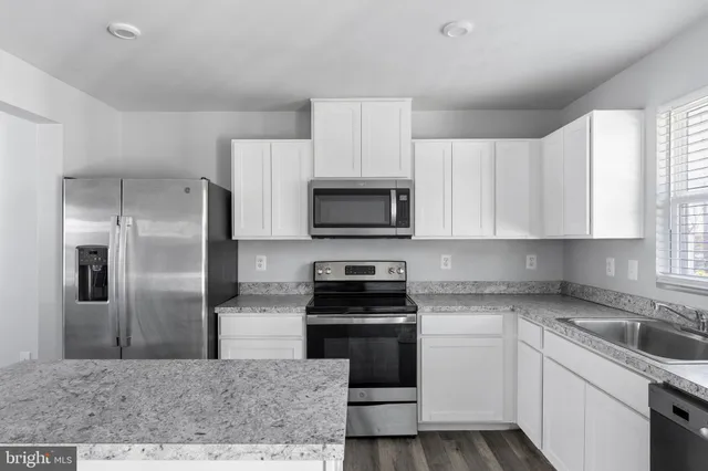 a kitchen with a sink stove and refrigerator