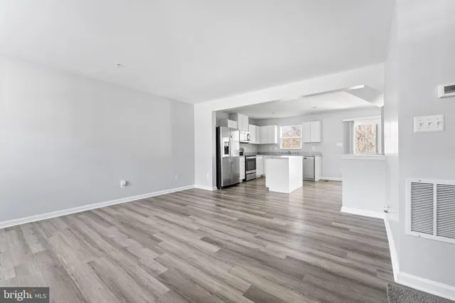 a view of a kitchen with wooden floor and a kitchen
