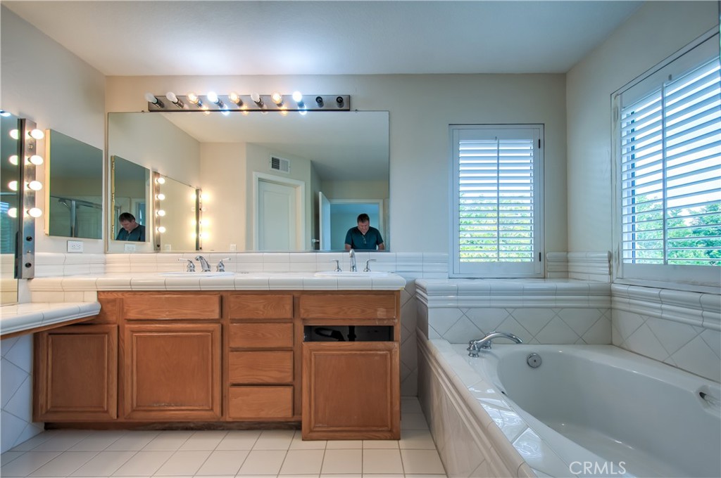 2 Altezza Irvine, CA 92606 - Photo 42 of 66 a spacious bathroom with a granite countertop sink two mirror a bathtub and next to a window
