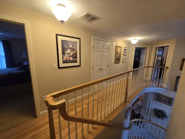a view of staircase with lots of frames on wall and a window