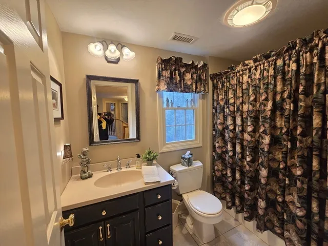 a bathroom with a toilet sink and mirror