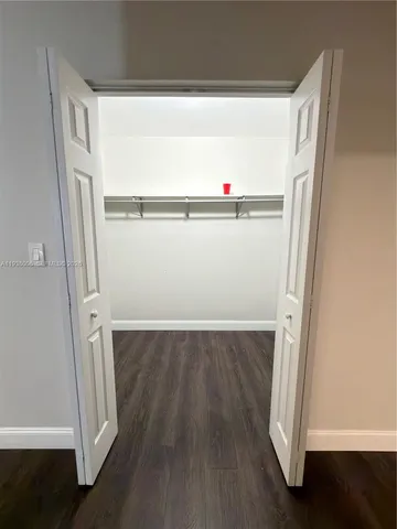 an empty room with wooden floor and closet