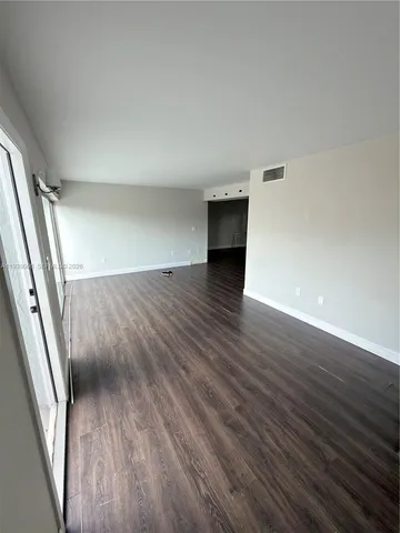 an empty room with wooden floor and door