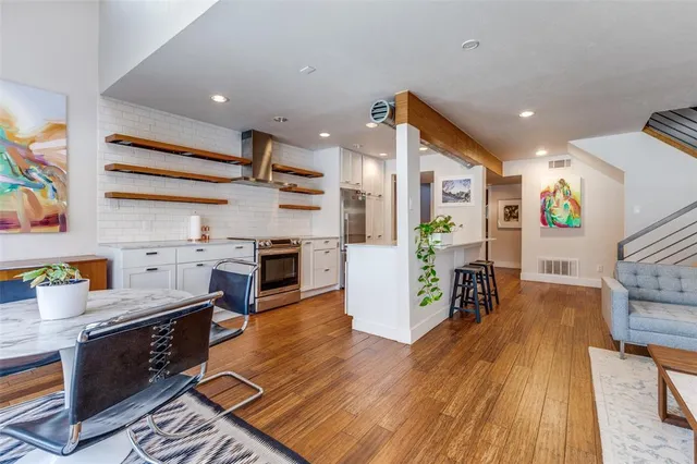 a open kitchen with stainless steel appliances granite countertop a stove and a wooden floors