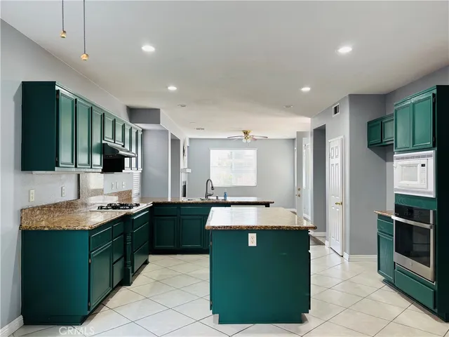 a kitchen with kitchen island a sink stainless steel appliances and cabinets