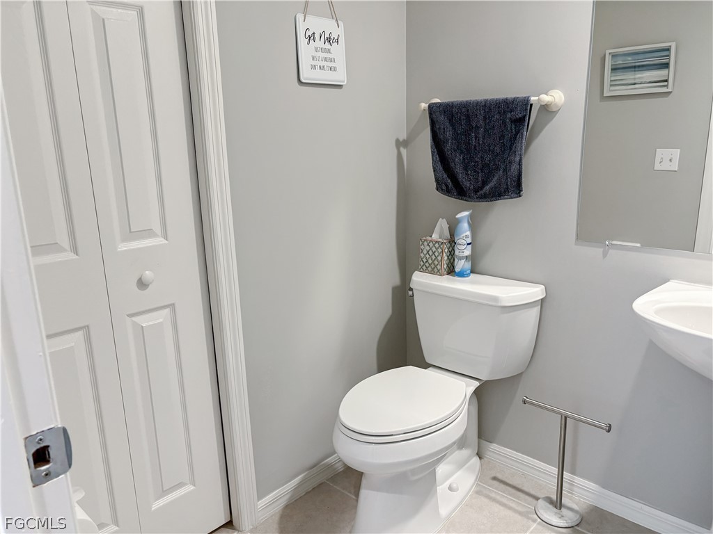 3269 Amanda Lane, Unit 2 Naples, FL 34109 - Photo 12 of 38 a bathroom with a toilet a sink and a mirror