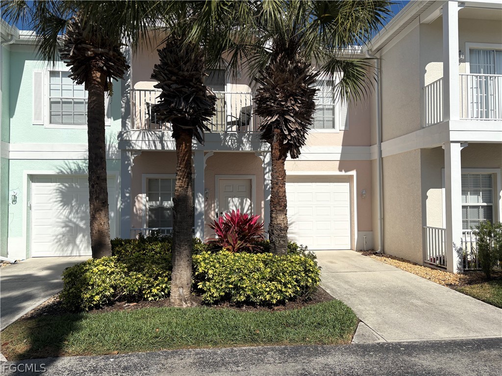 3269 Amanda Lane, Unit 2 Naples, FL 34109 - Photo 2 of 38 a front view of a house with a yard and potted plants