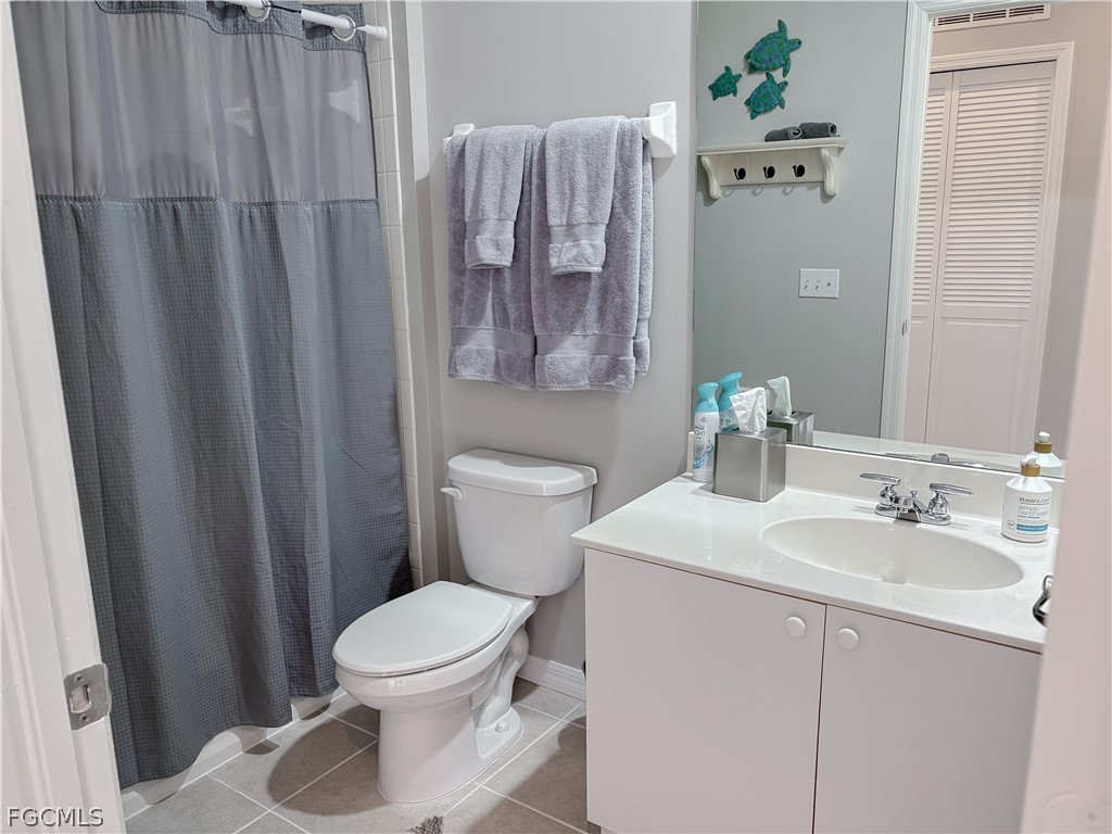 3269 Amanda Lane, Unit 2 Naples, FL 34109 - Photo 23 of 38 a bathroom with a sink a toilet and shower curtain