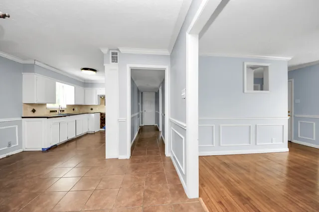 a view of a kitchen with kitchen island white cabinets and refrigerator