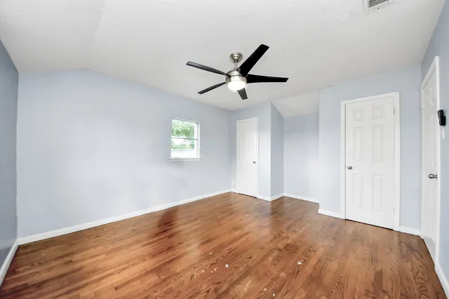 a view of empty room with wooden floor