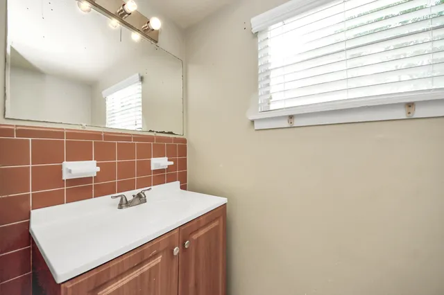 a bathroom with a sink a vanity and a window