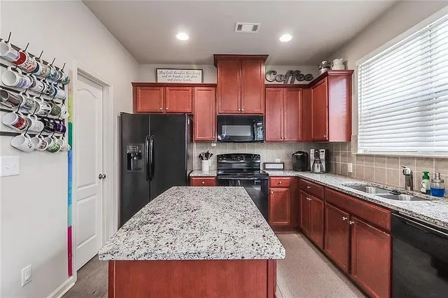 a kitchen with stainless steel appliances granite countertop a refrigerator stove microwave and sink