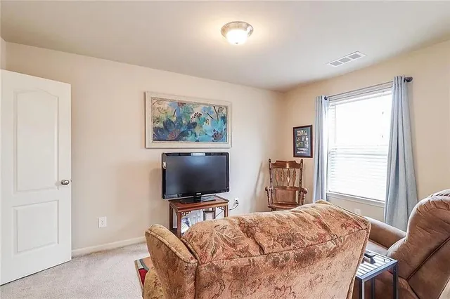 a bedroom with furniture and a flat screen tv
