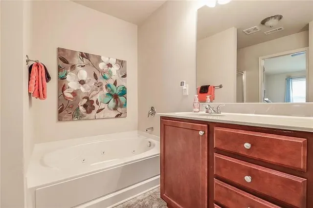 a bathroom with a tub sink and mirror