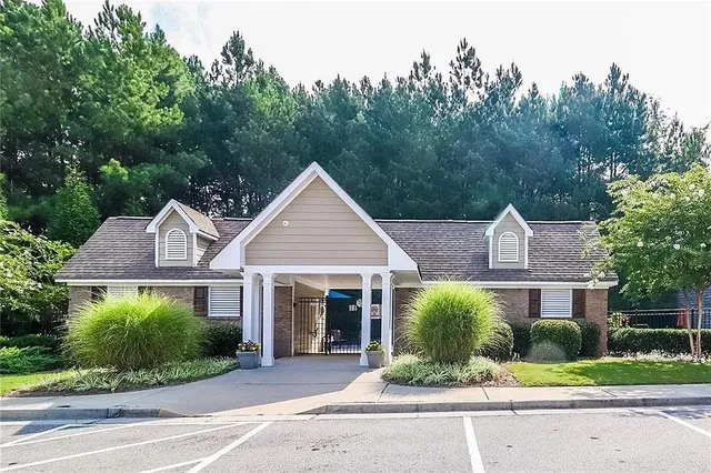 a front view of a house with a yard and potted plants