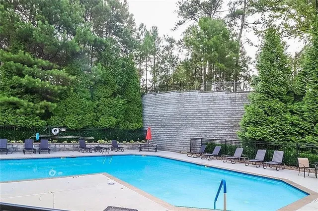 a view of a backyard with swimming pool and sitting area