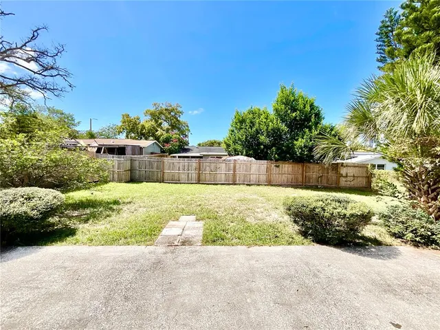 a view of backyard with couple of plants and trees