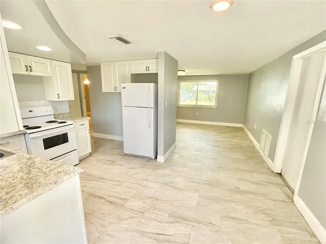 a kitchen with a refrigerator a stove top oven a refrigerator and a sink