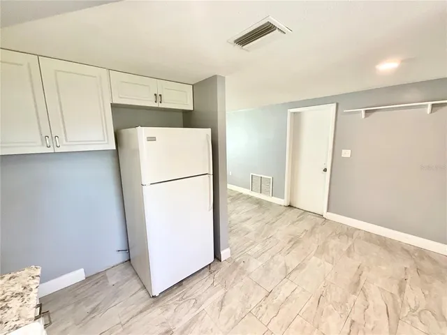 a view of kitchen with refrigerator and wooden floor