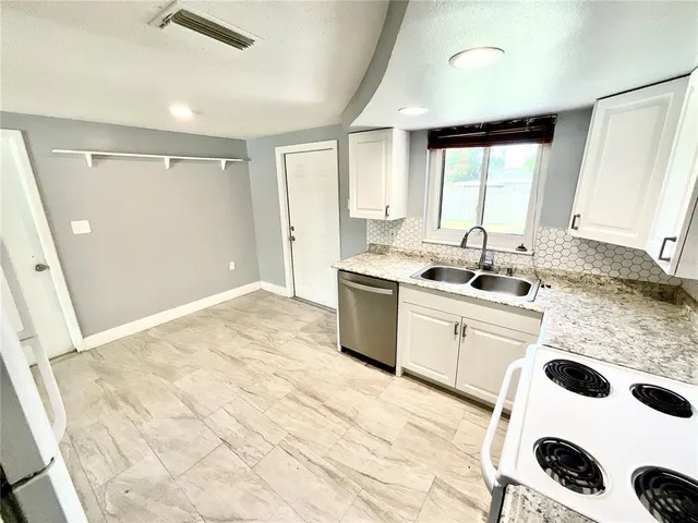a kitchen with a sink a window and cabinets