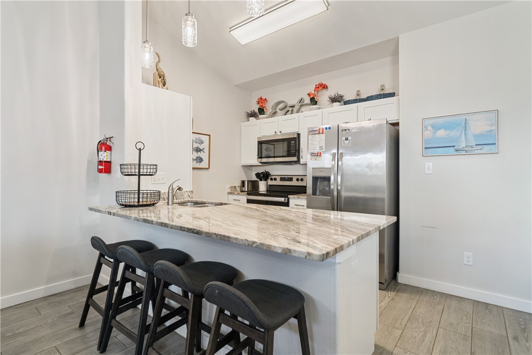 15113 Kokomo Drive Corpus Christi, TX 78418 - Photo 7 of 25 a kitchen with granite countertop a refrigerator and a stove top oven