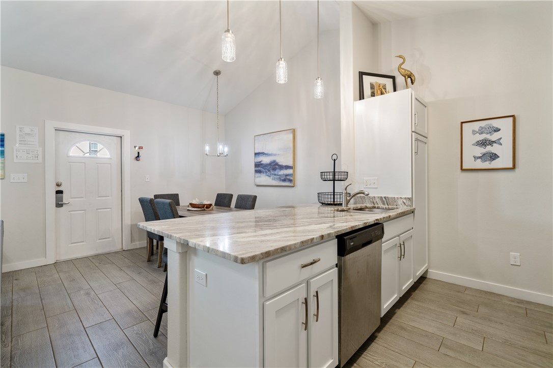 15113 Kokomo Drive Corpus Christi, TX 78418 - Photo 8 of 25 a hall with kitchen island a sink dishwasher a stove with wooden floor