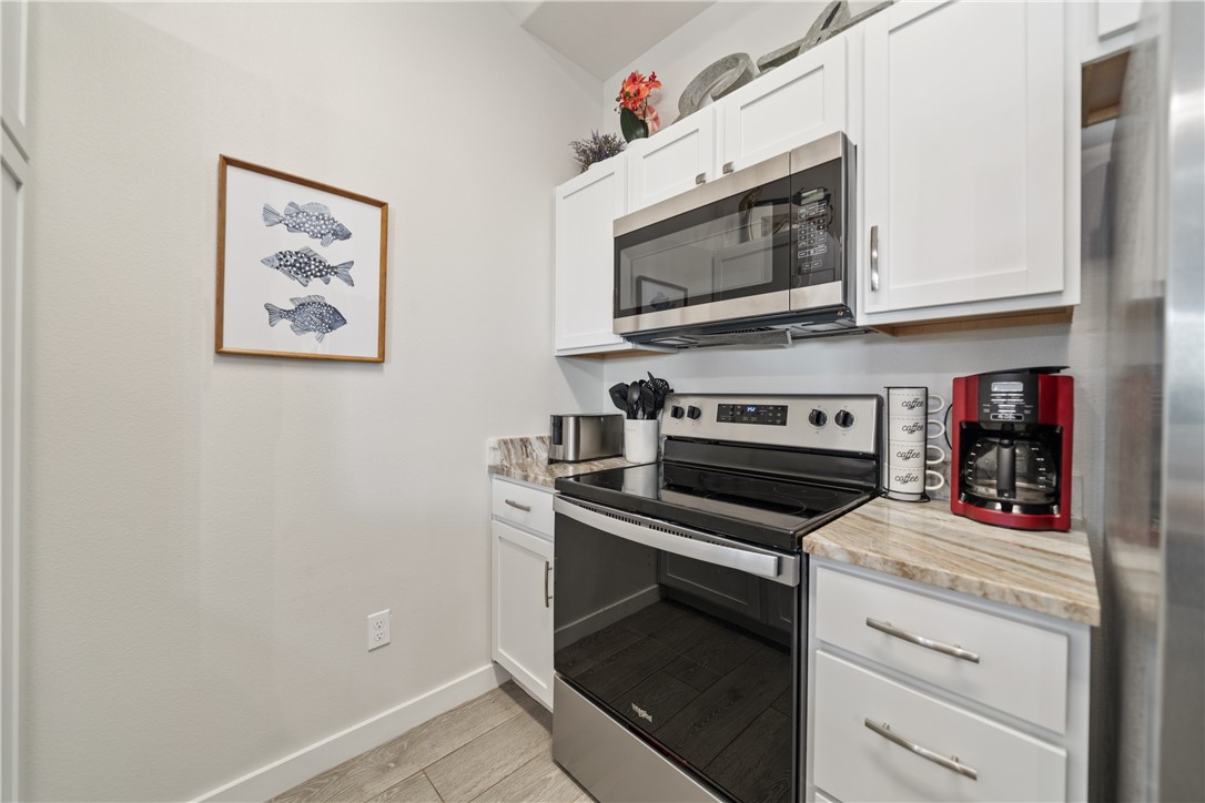 15113 Kokomo Drive Corpus Christi, TX 78418 - Photo 9 of 25 a kitchen with white cabinets and stainless steel appliances