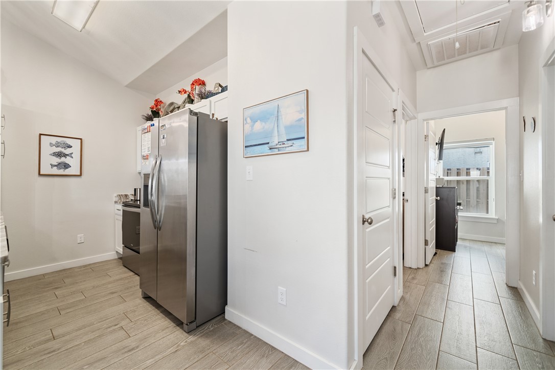 15113 Kokomo Drive Corpus Christi, TX 78418 - Photo 10 of 25 a view of a kitchen with refrigerator and wooden floor