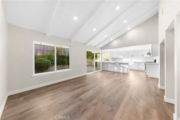 a view of a kitchen with wooden floor and a window