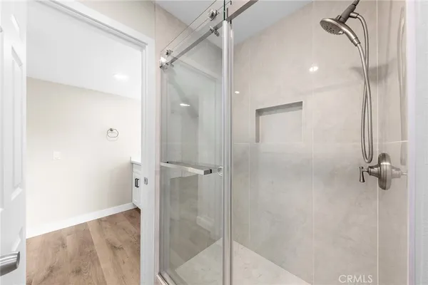 a bathroom with a sink a toilet a mirror and shower